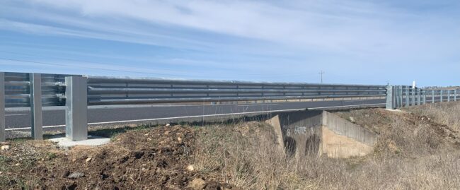 A wide shot of the crocguard bridge and culvert barrier installed over a culvert